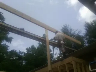 Carpenter setting a ridge beam over a new addition frame — Ice Dam Removal by Roofing Brothers in Garrattsville