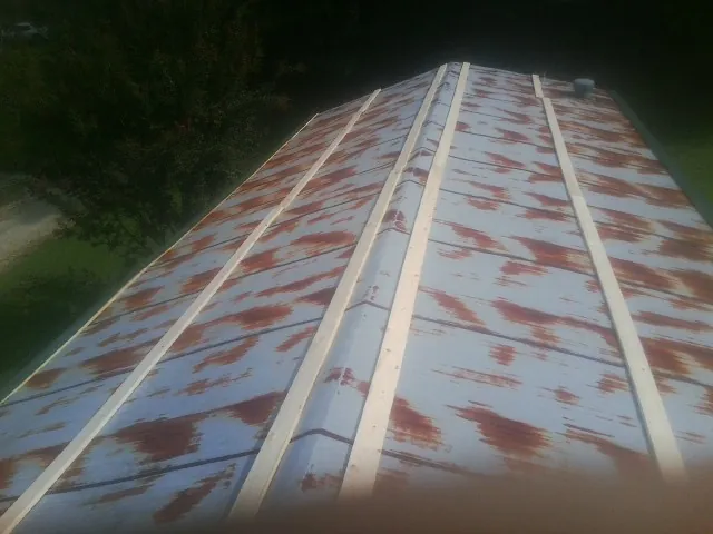 Rusted metal roof panels with new wood purlins before replacement — Storm Damage Roof Repair in Garrattsville by Roofing Brothers