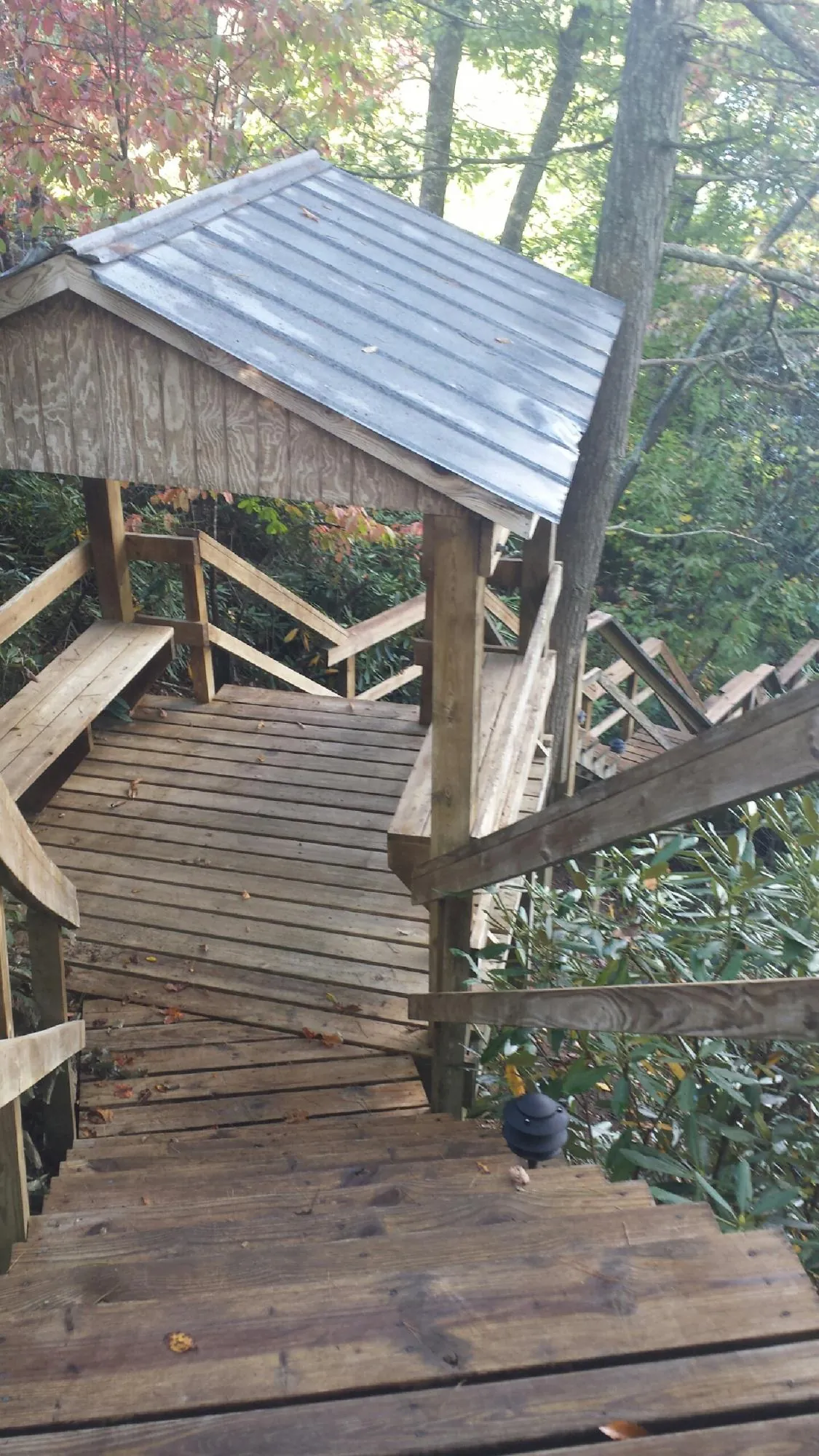 Metal roofed shelter over wooden steps on a wooded walkway — Skylight Repair & Installation work by our crew in Garrattsville