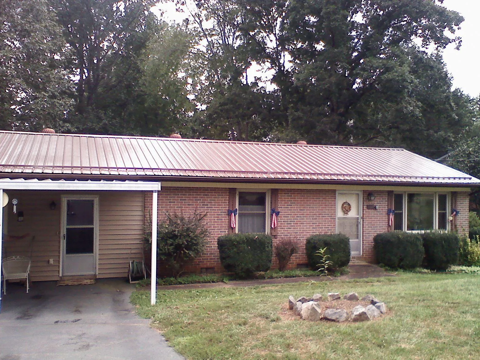 Bronze metal roof and carport on a brick ranch home — Roof Repair work by our crew in Garrattsville